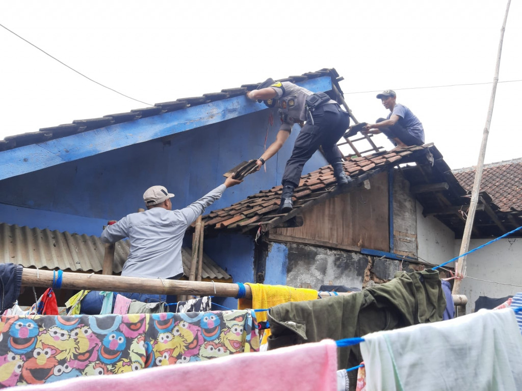 Bersama Warga, Bhabinkamtibmas Gotong Royong Bersihkan Material Pasca Angin Puting Beliung