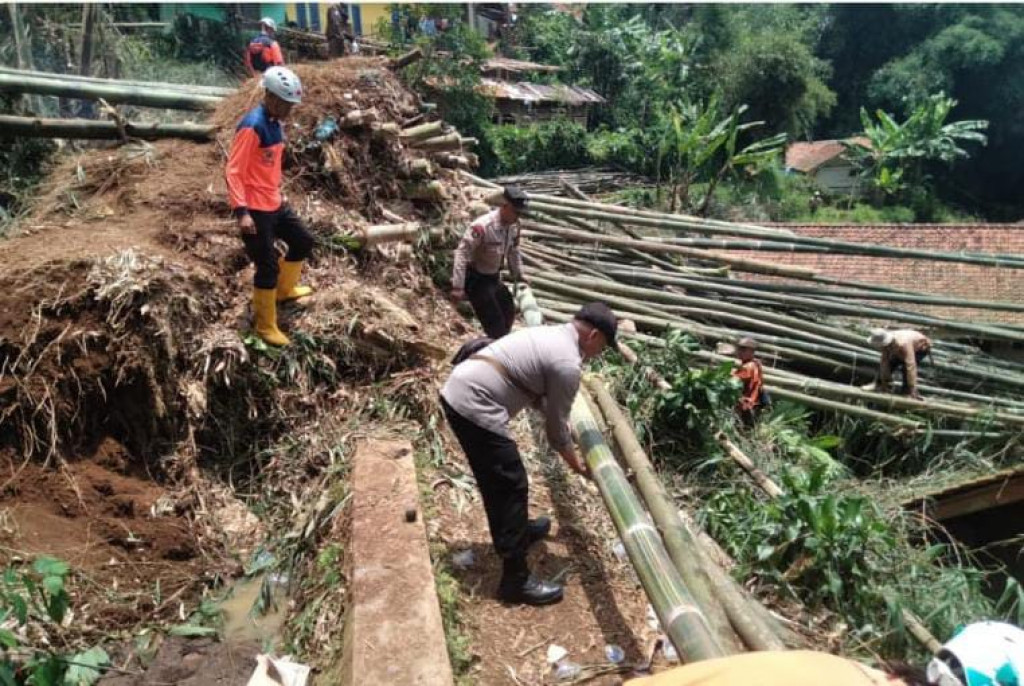 Polsek Sukasari Polres Sumedang Bantu Warga Bersihkan Runtuhan Bambu yang Menimpa Rumah Warga